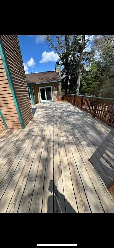 A wide wooden deck with a house and trees in the background in egg harbor township, nj