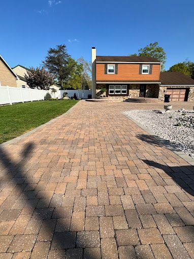 brick paver driveway leading to a two-story house with brown and stone exterior repaired by melo powerwashing & painting in somers point, nj