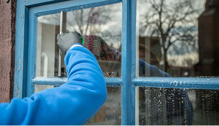 person cleaning outside windows