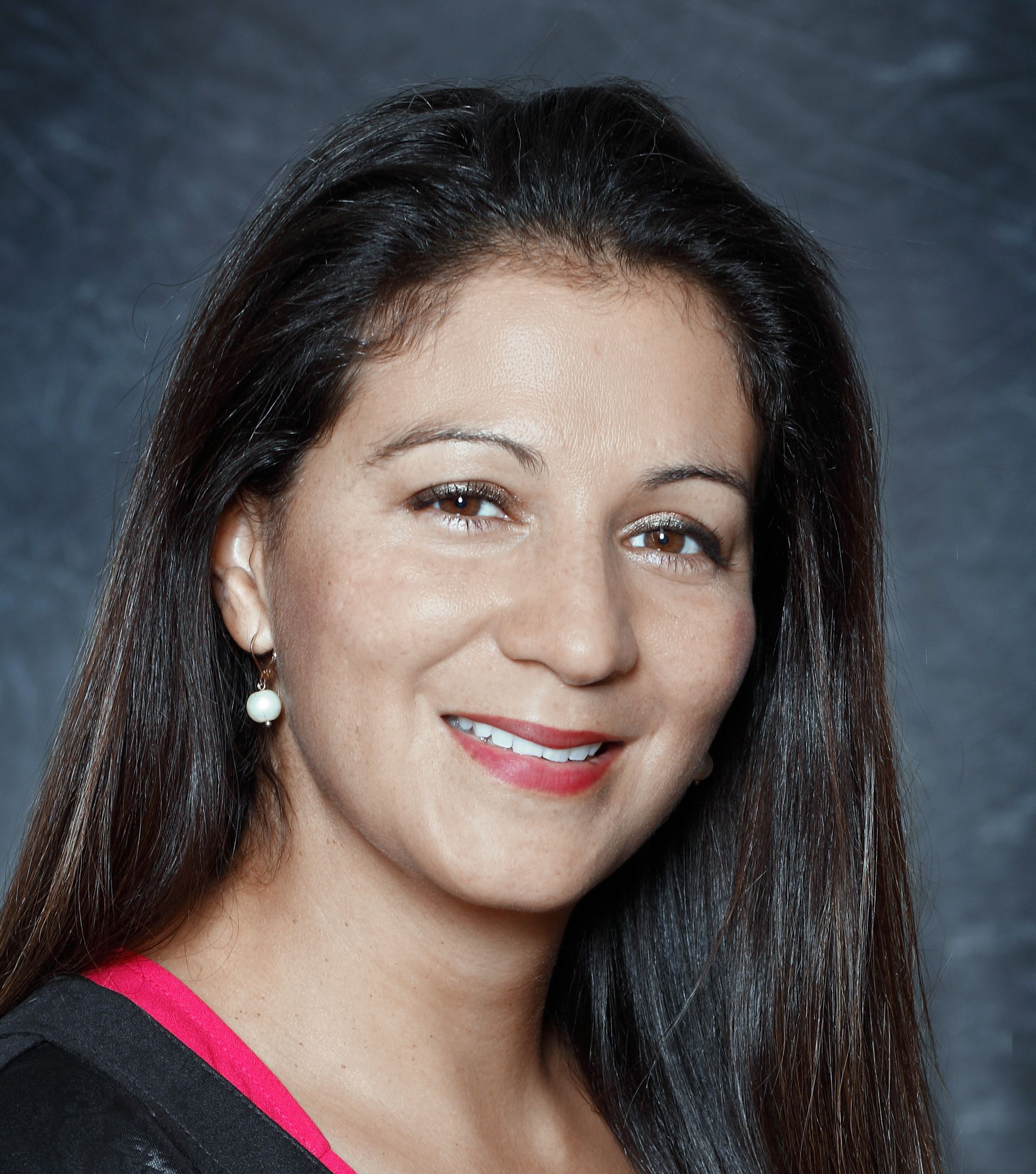 A woman with long hair is smiling for the camera