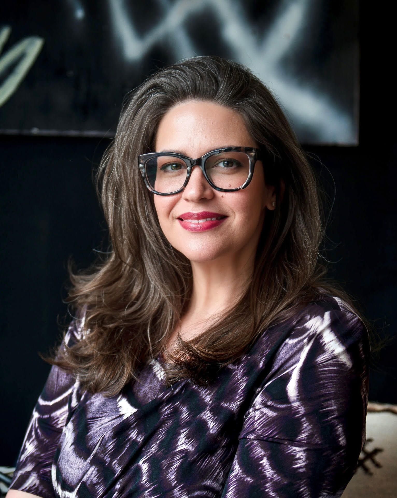 Man with light hair and blue tie smiles at the camera, wearing a light blue shirt.