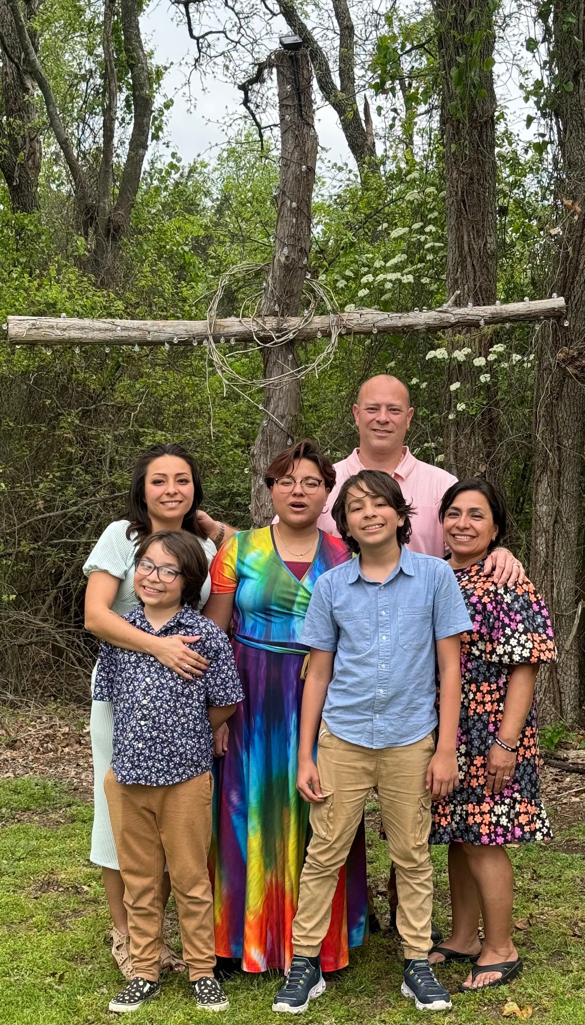 A group of people are posing for a picture in front of trees.