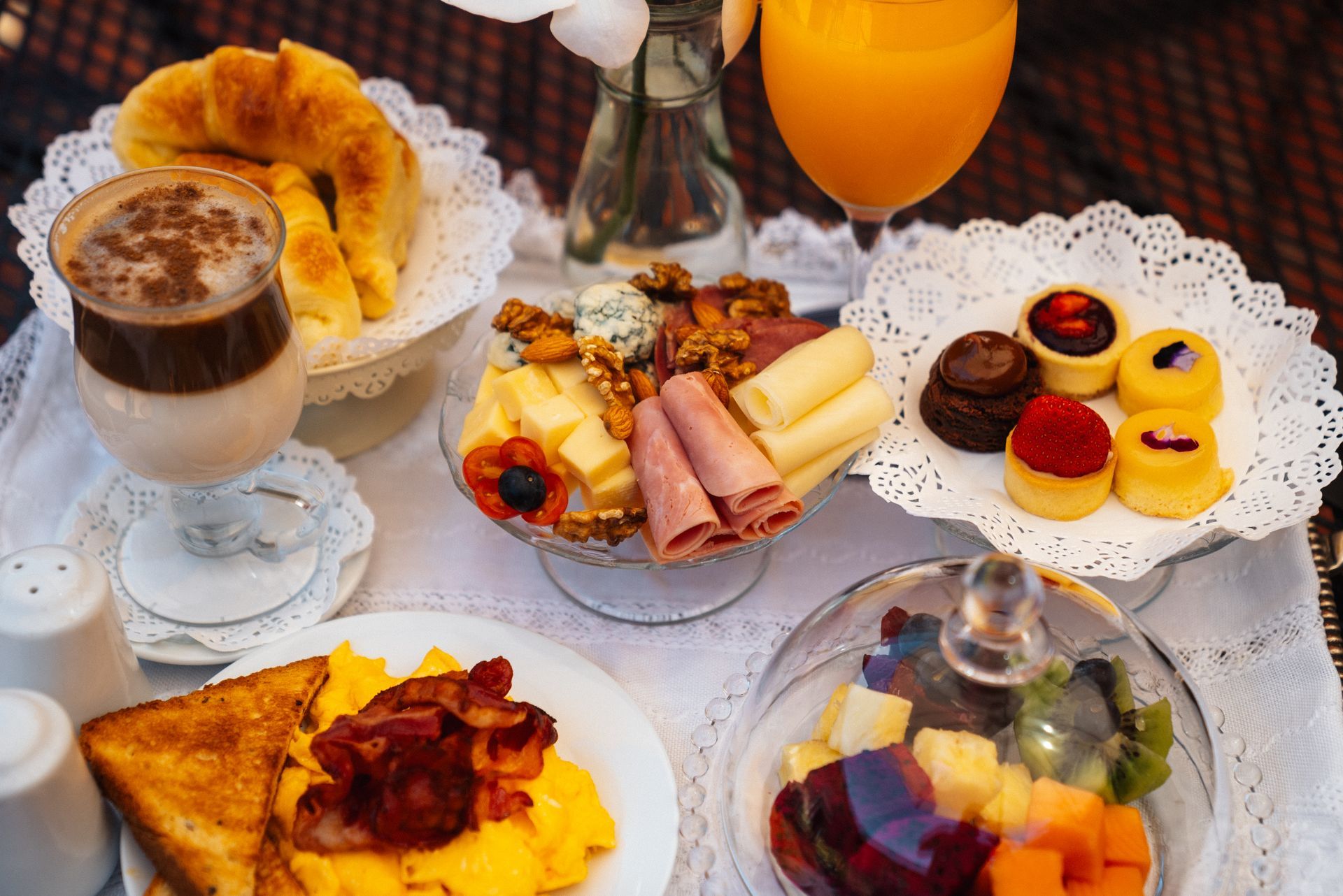 Un desayuno completo con café, zumo de naranja, un cruasán, huevos, beicon, tostadas, quesos variados, embutidos, fruta y bollería.