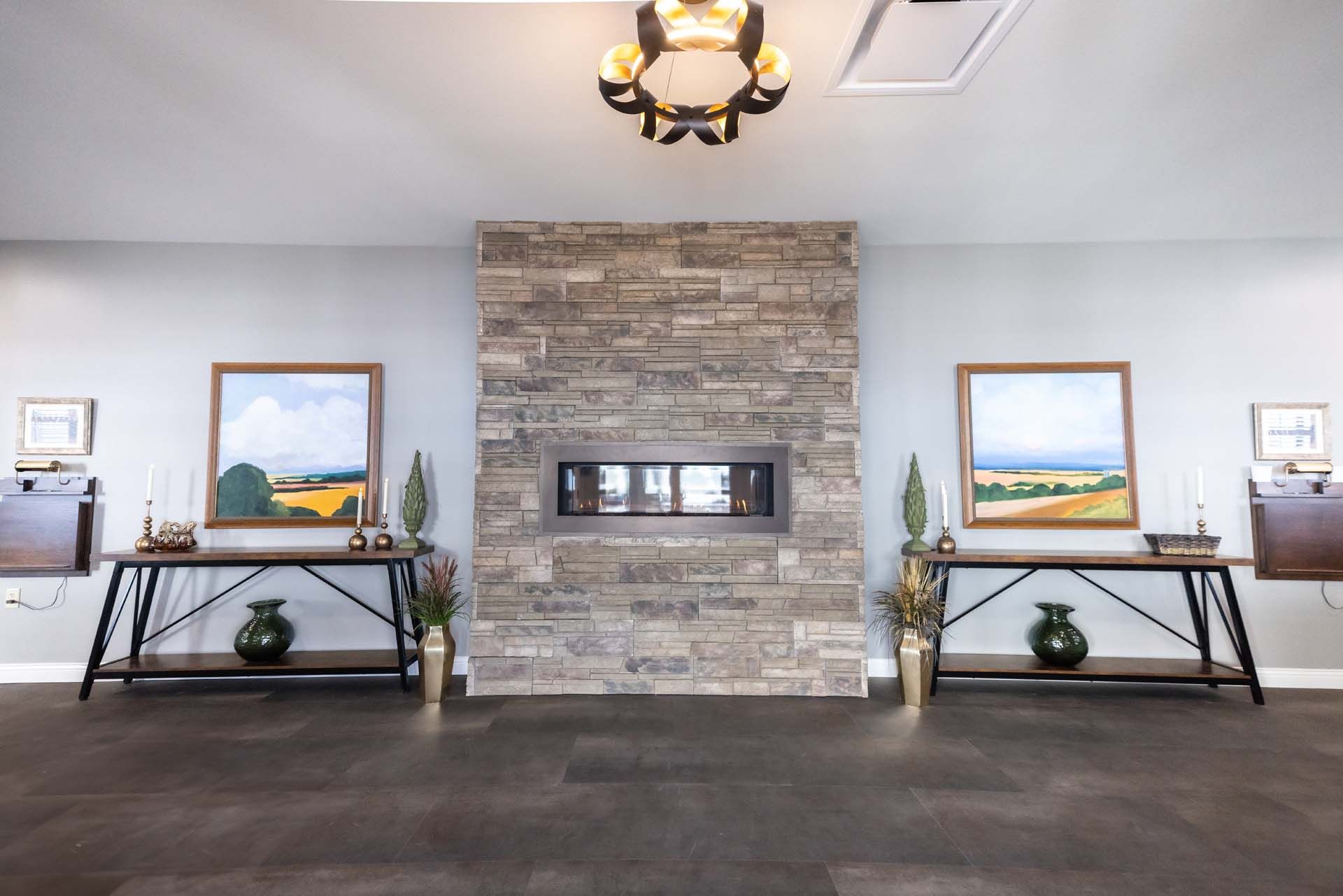 a living room with a fireplace and paintings on the wall