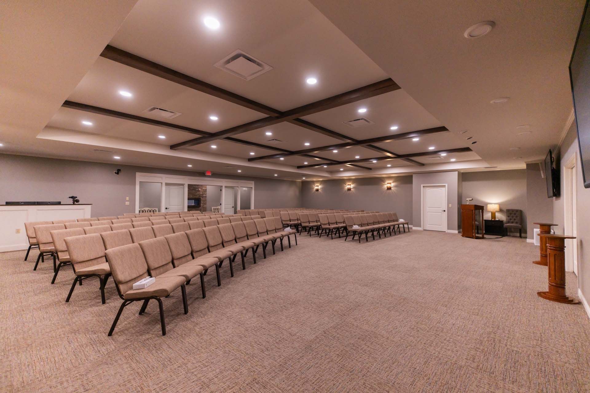 a large empty auditorium with rows of chairs and a podium .