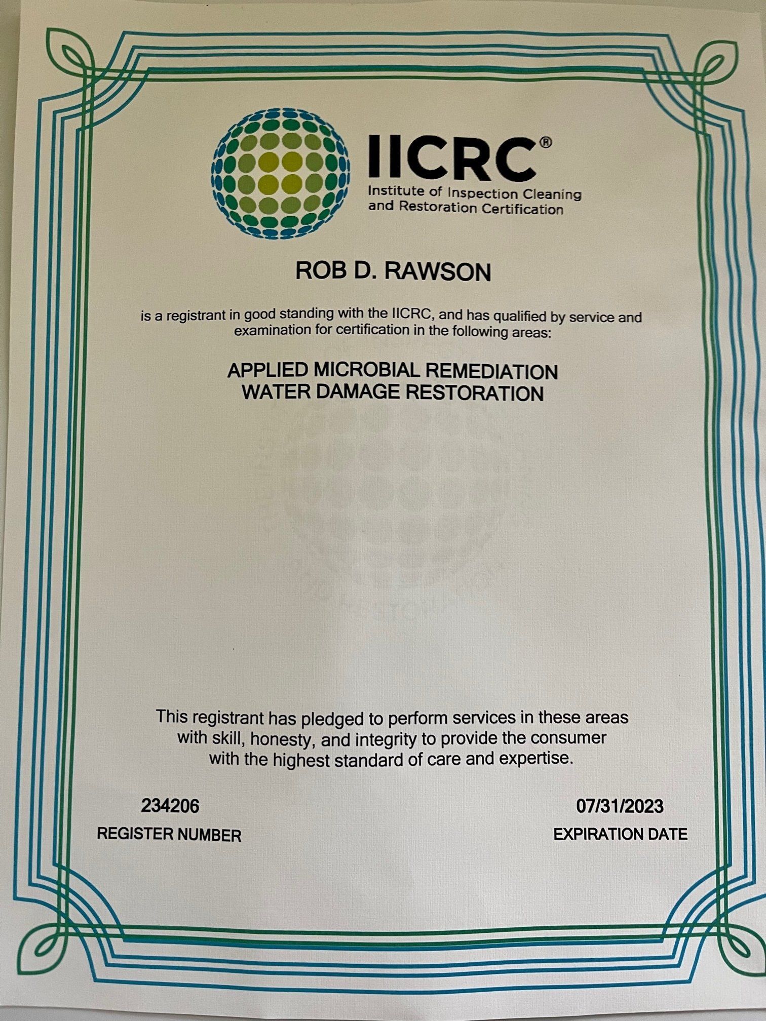 A certificate from iicrc is sitting on a table.