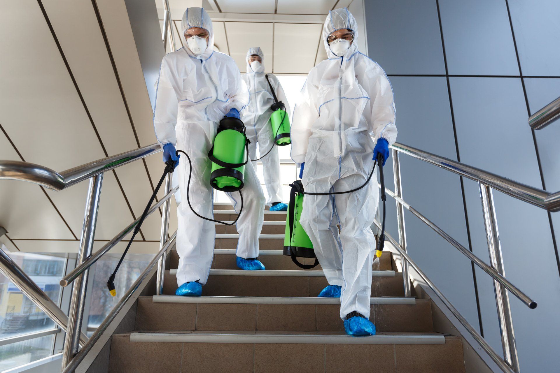 A group of people in protective suits are walking down stairs.