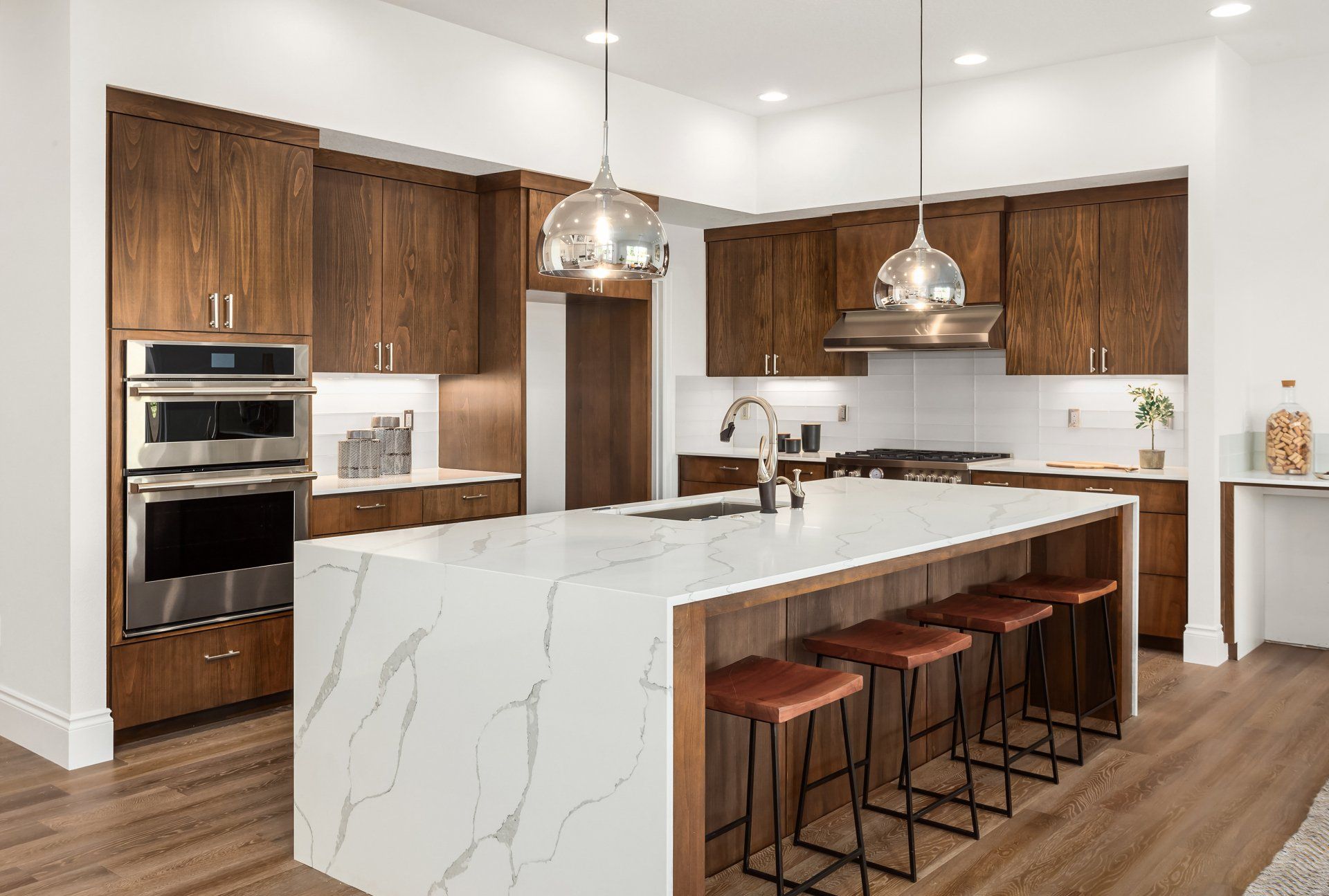 A kitchen with marble counter tops , wooden cabinets , stainless steel appliances , and a large island.