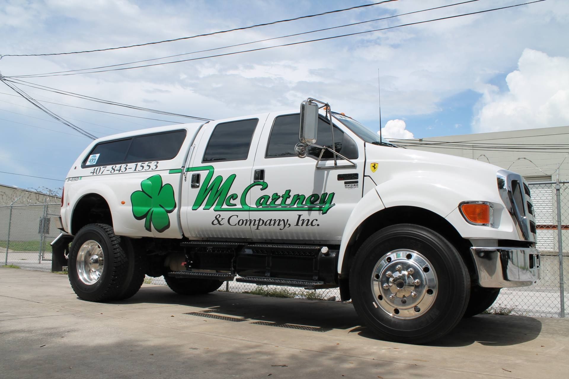 An individual wearing a red cap and blue-striped shirt driving a vehicle while looking out the side window.