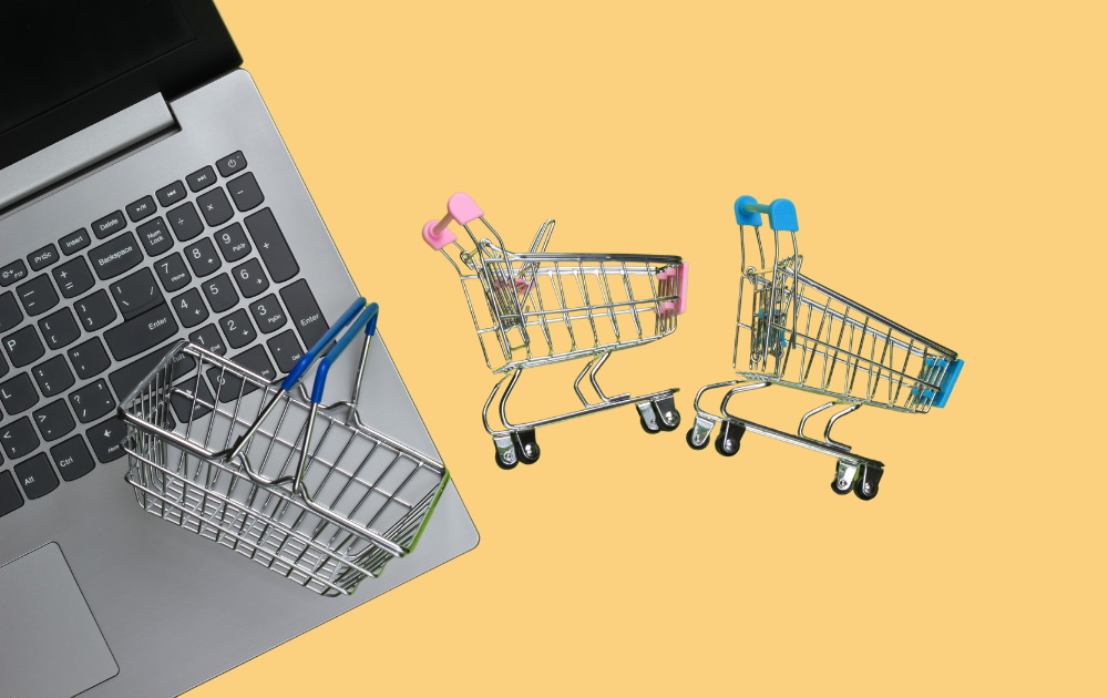 Two shopping carts are sitting on top of a laptop computer.