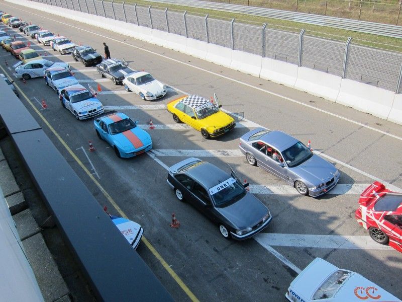 A row of cars are lined up on a race track