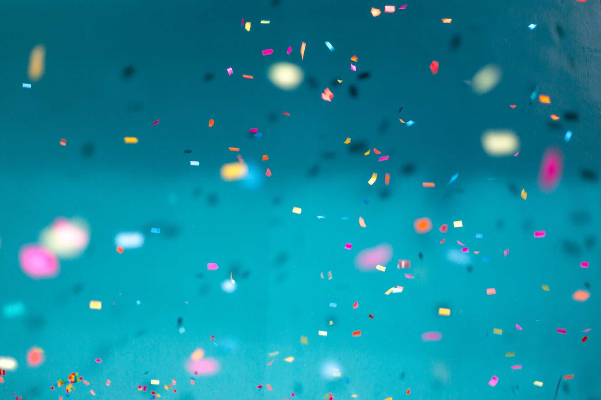 Colorful confetti falling against a blue background