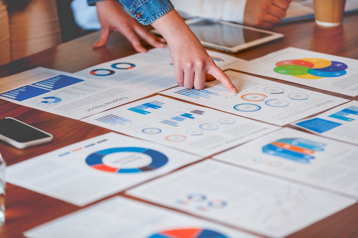 A person is pointing at a graph on a table.