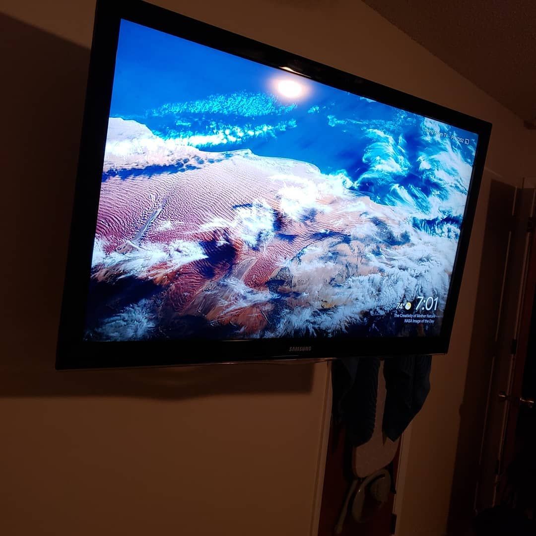 Television screen on wall displays a cloudy sky view.