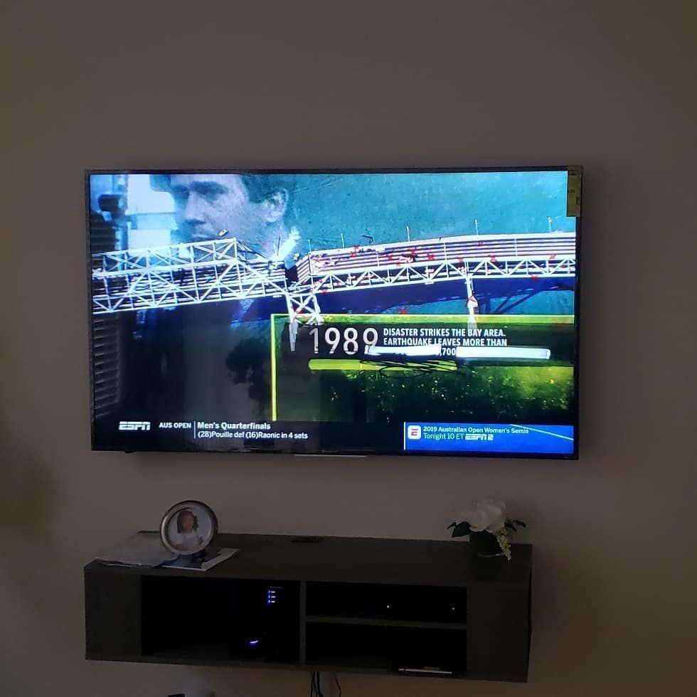 TV screen showing a sports broadcast from 1989, mounted above a floating console.