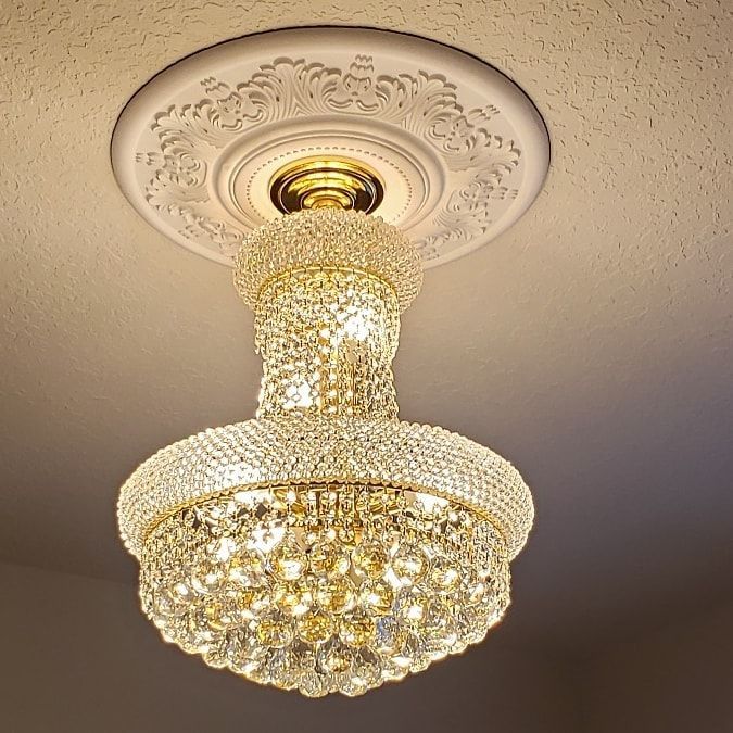 LED light fixture with ribbed, clear glass shade, mounted on a tan stucco wall.