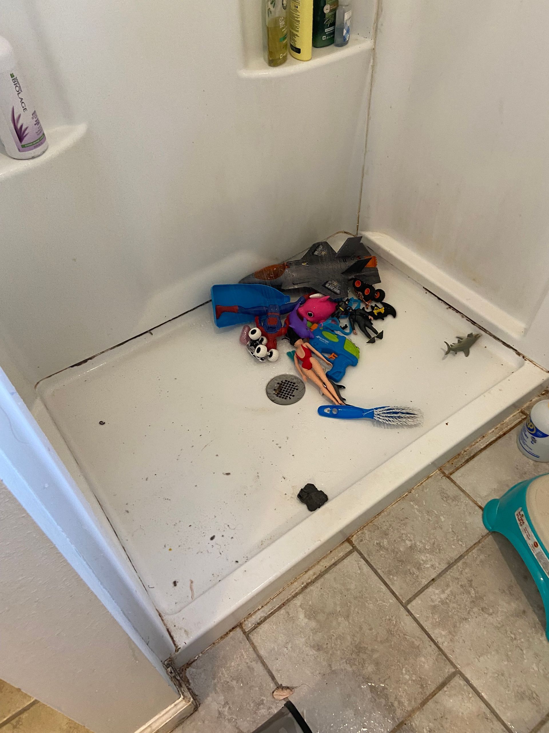 A shower stall with a lot of toys in it.