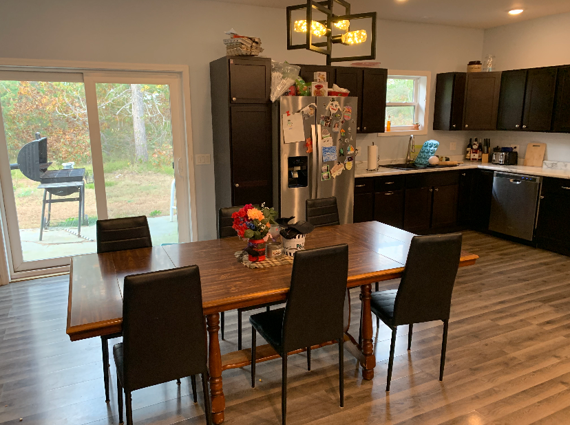 A kitchen with a table and chairs and a refrigerator.