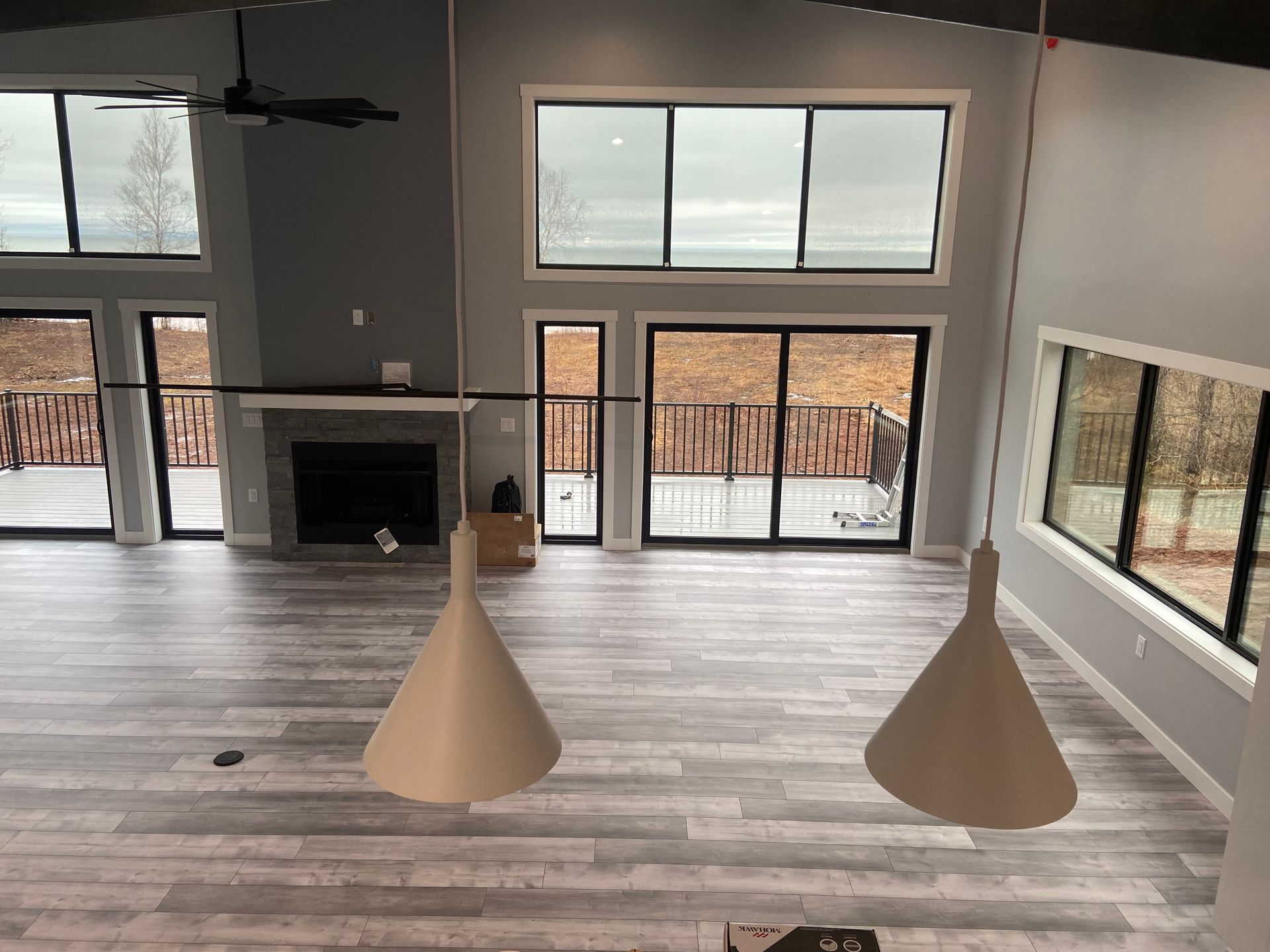A large empty living room with a fireplace and sliding glass doors.