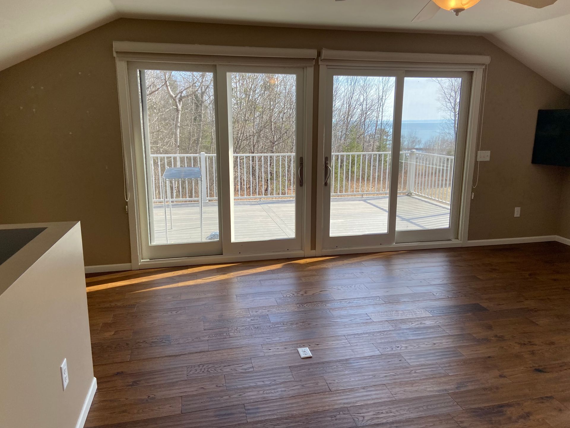 An empty living room with sliding glass doors leading to a balcony
