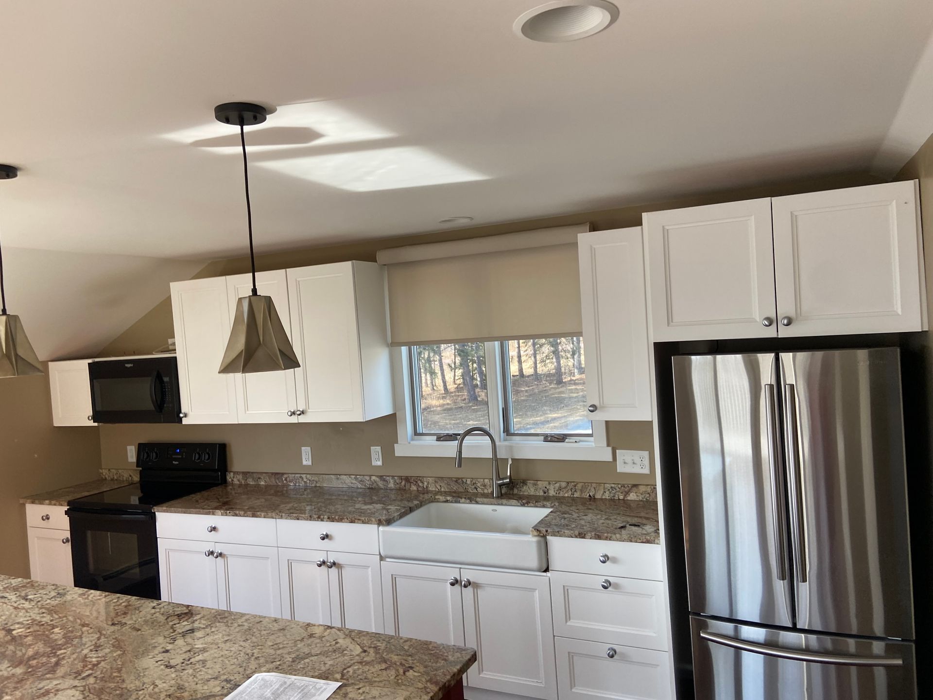 A kitchen with stainless steel appliances and white cabinets