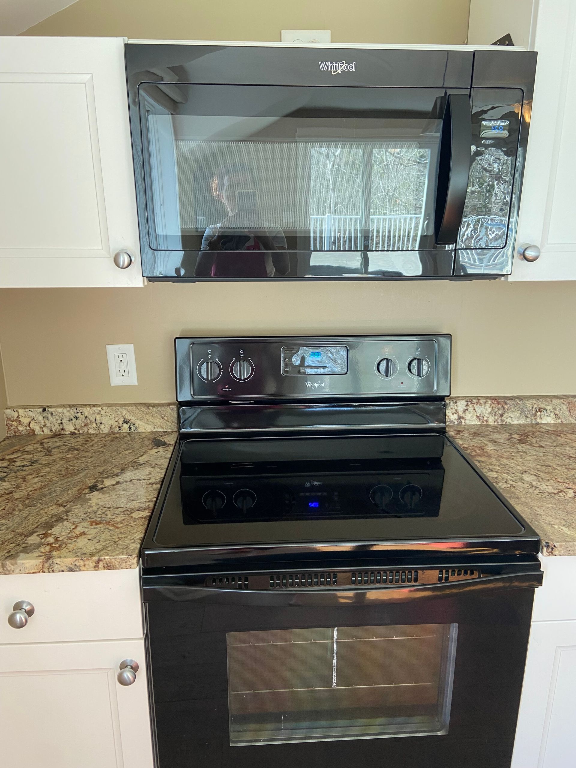 A black stove top oven with a microwave above it in a kitchen.