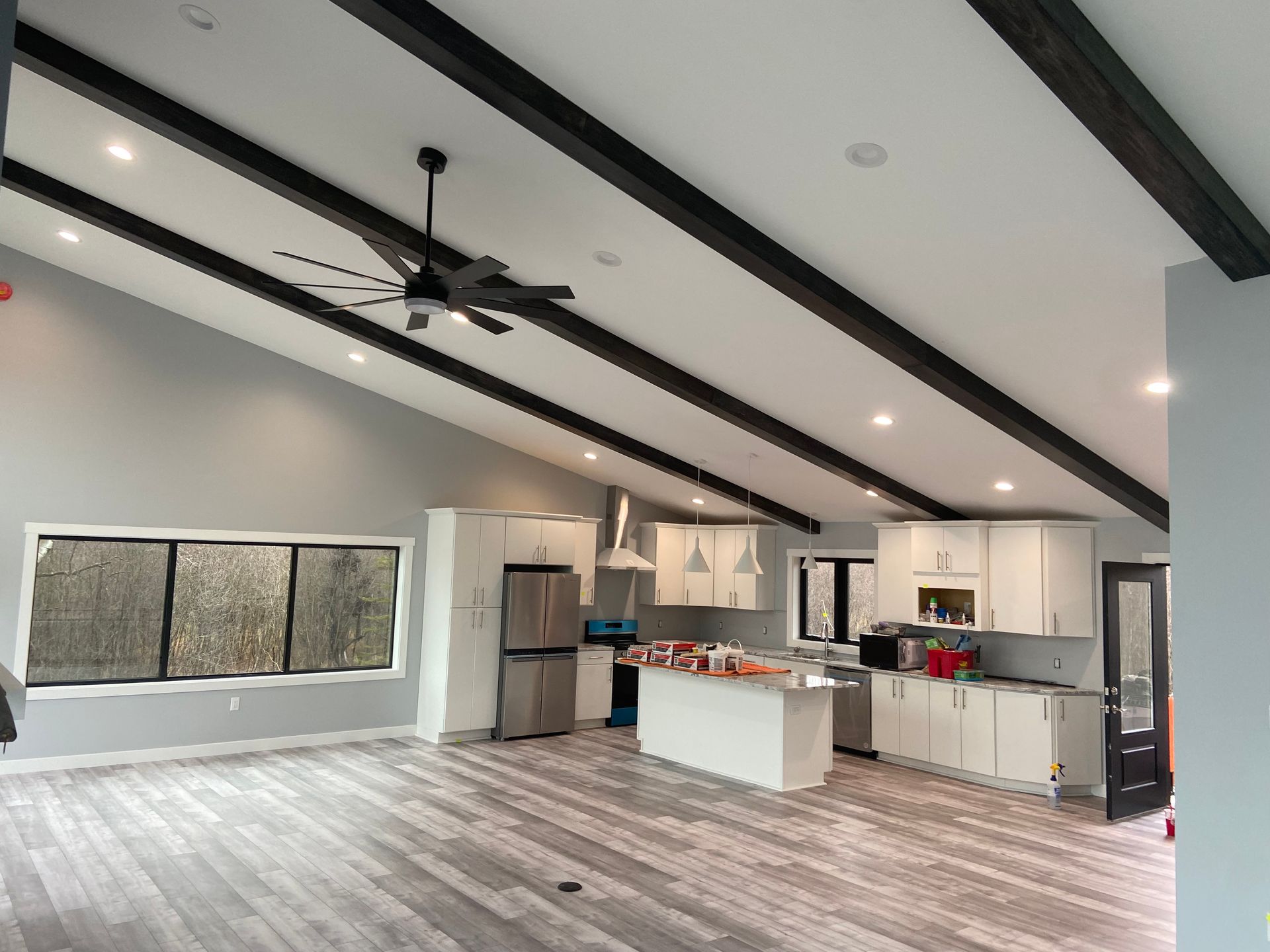 A kitchen with white cabinets and a ceiling fan