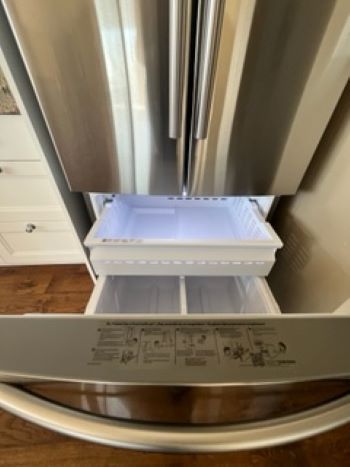 The inside of a stainless steel refrigerator with the door open.