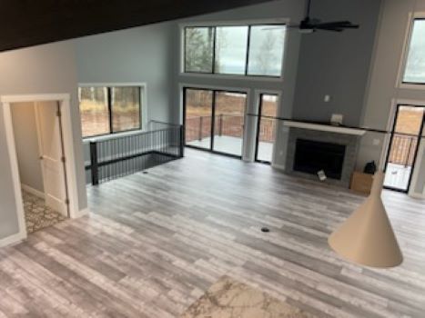 A large living room with a fireplace and lots of windows.