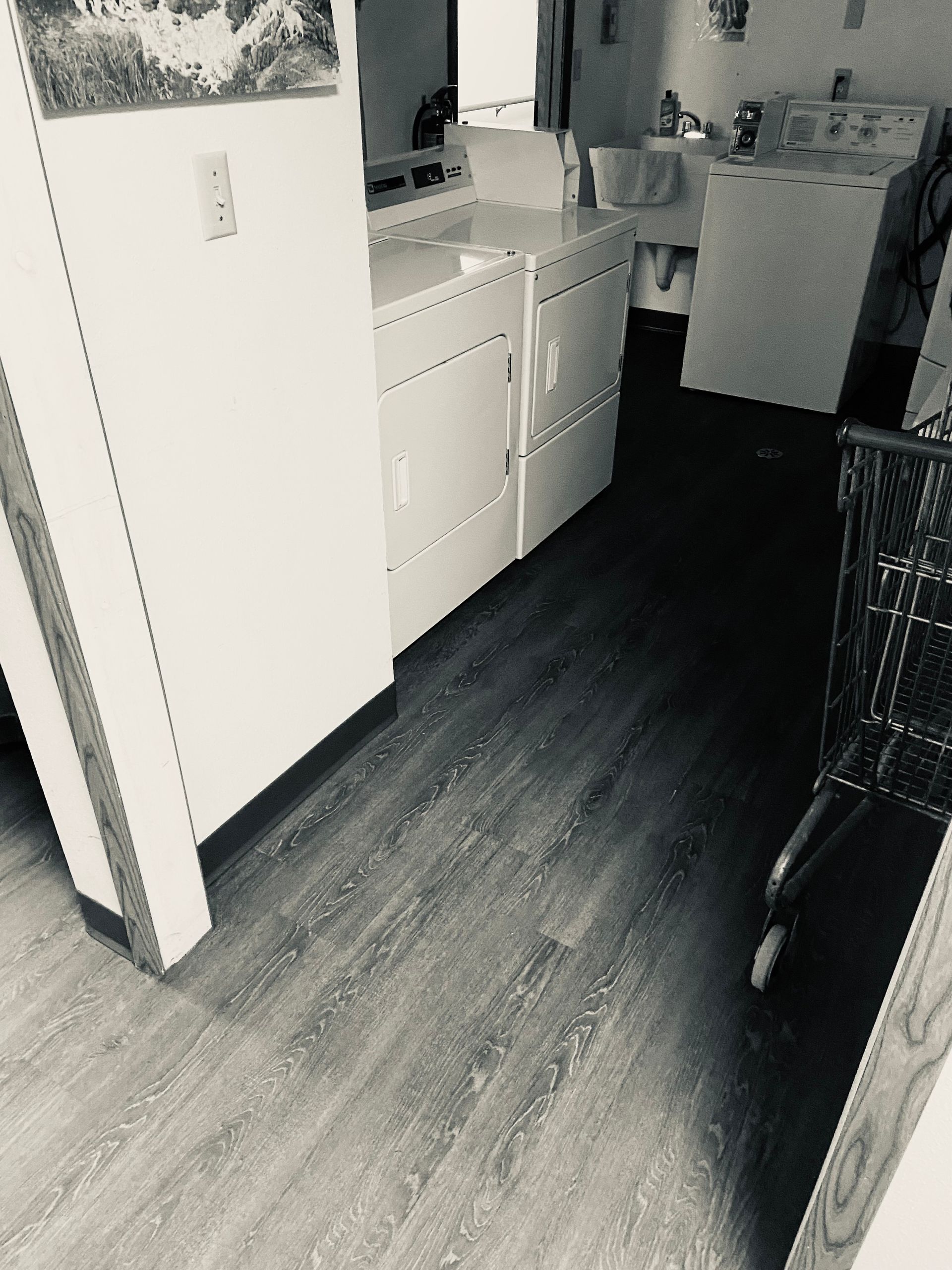 A black and white photo of a laundry room with a washer and dryer.