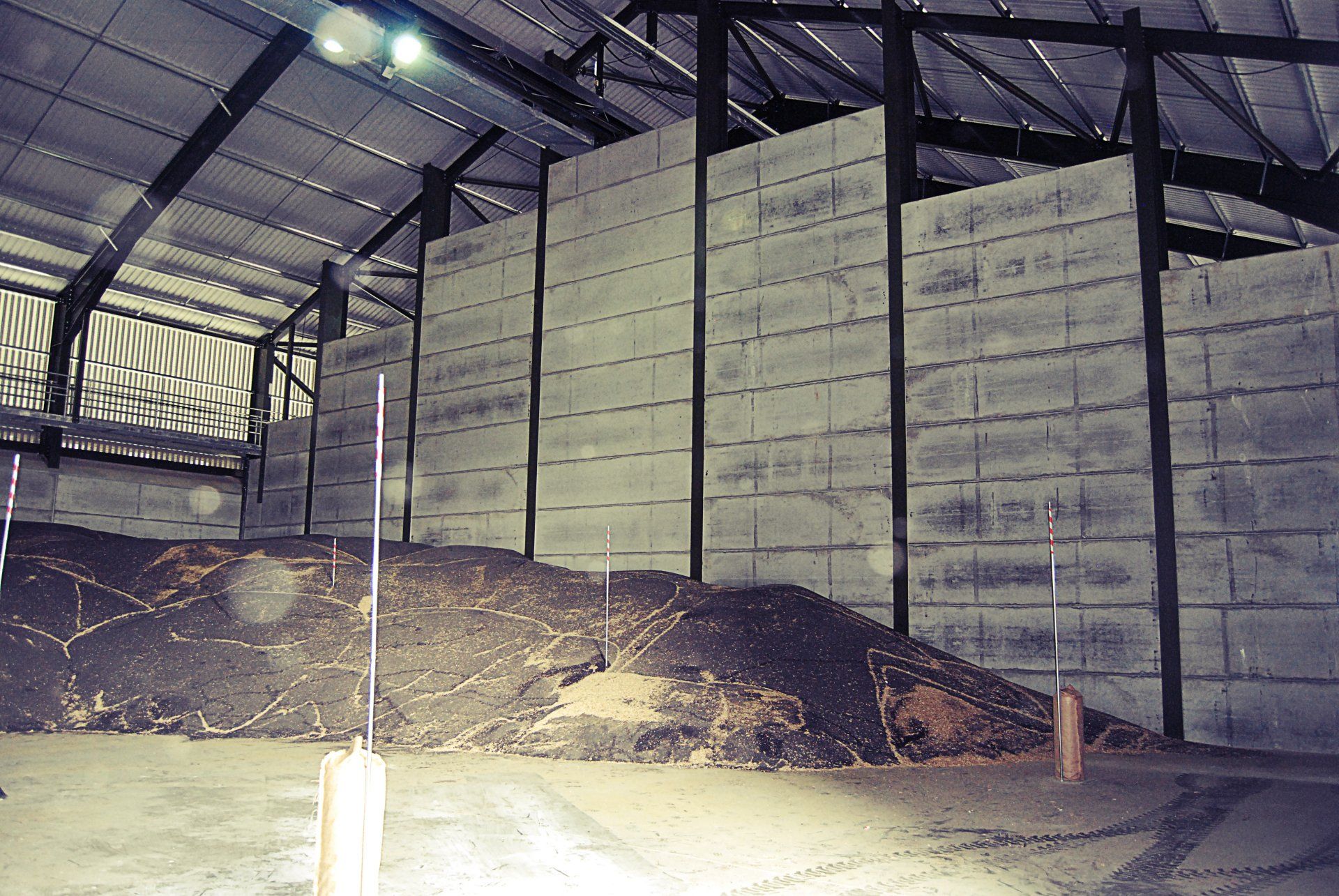 An empty warehouse with a large pile of dirt in the middle