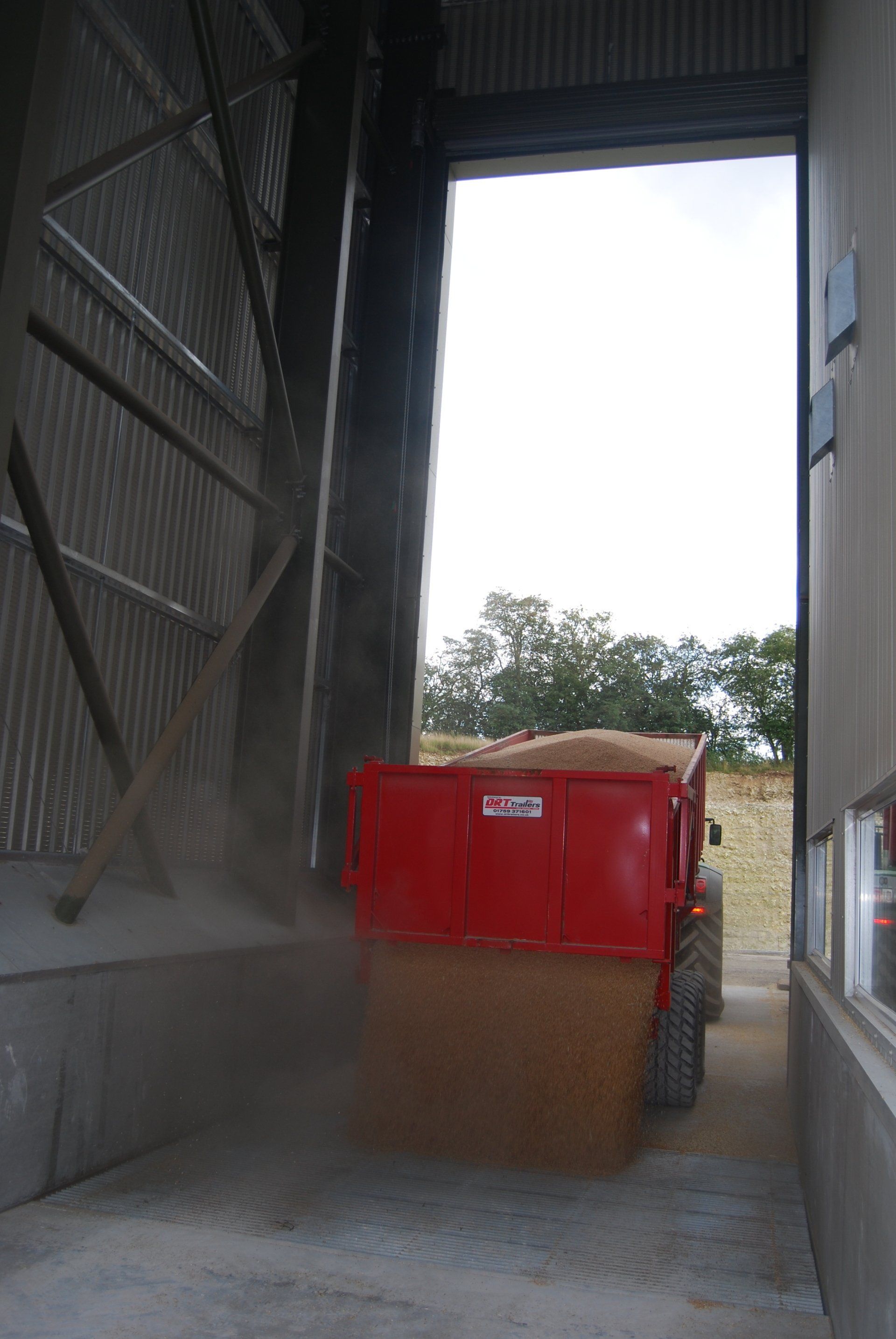 A red dumpster is being loaded into a building