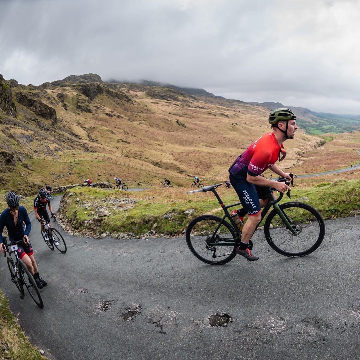 A group of people are riding bicycles down a road.