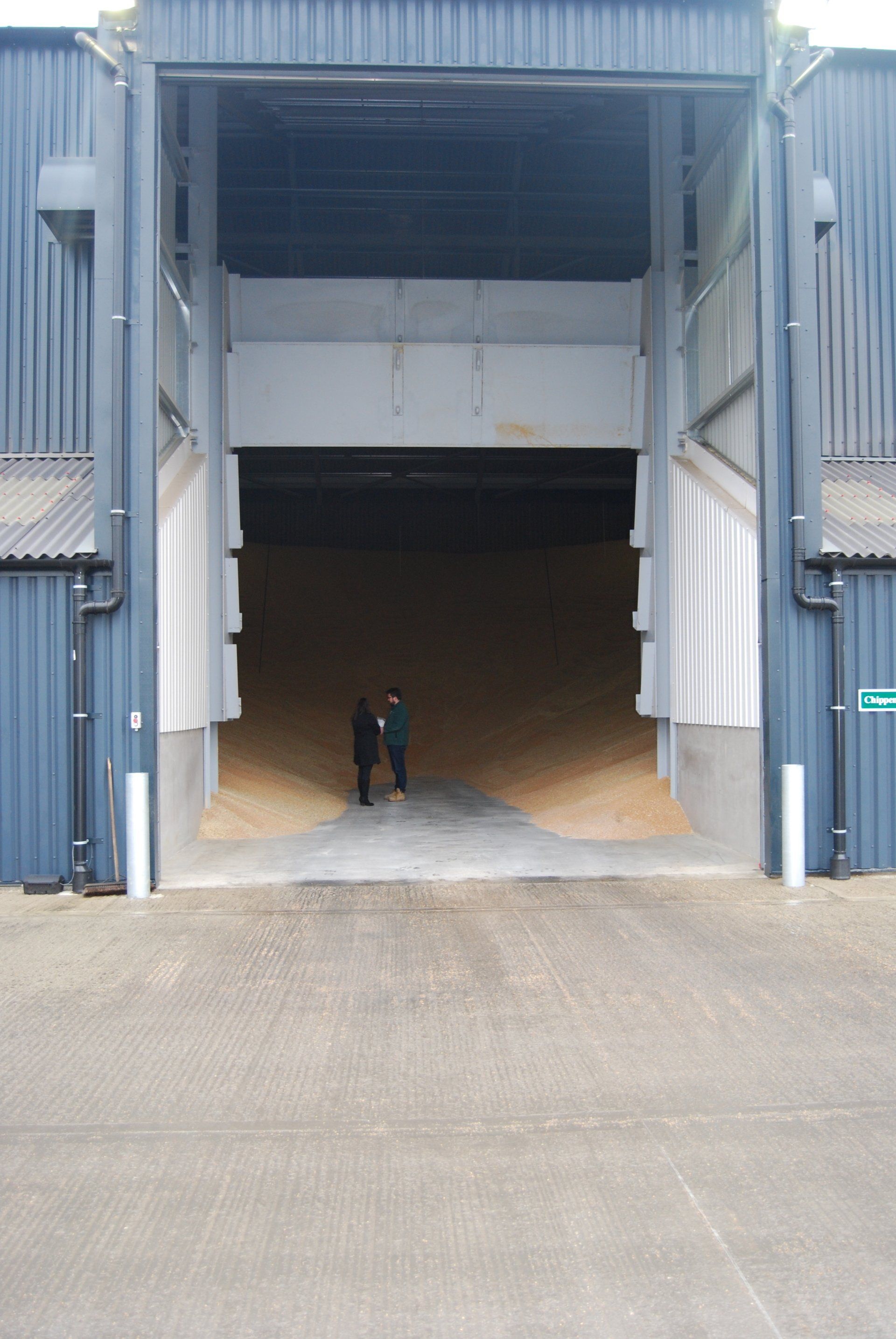 Two men standing in front of a large warehouse door