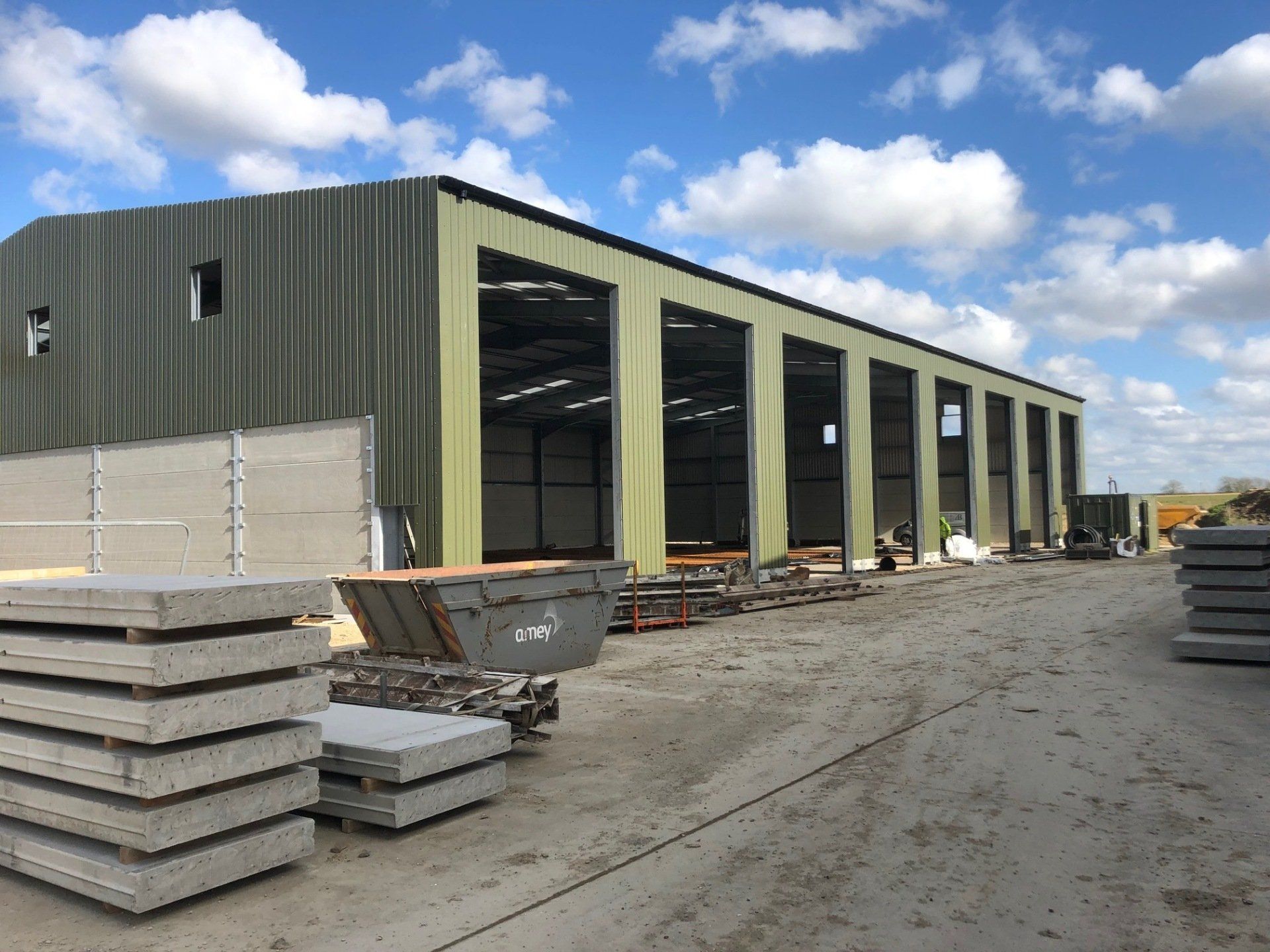 A large green building with a lot of concrete in front of it.