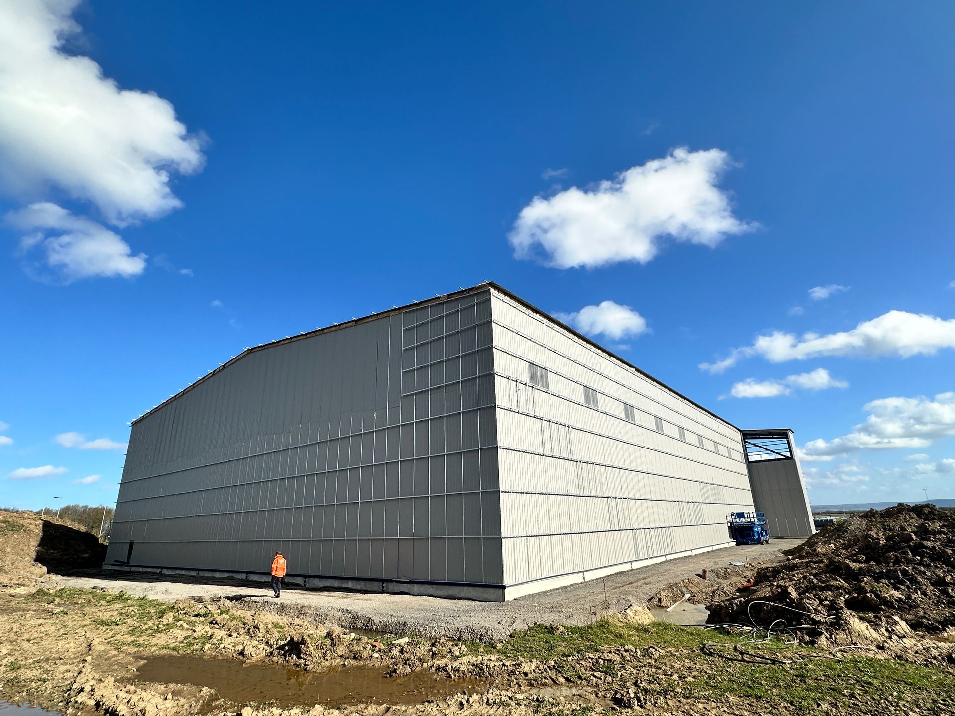 A large white building with a blue sky and clouds in the background.