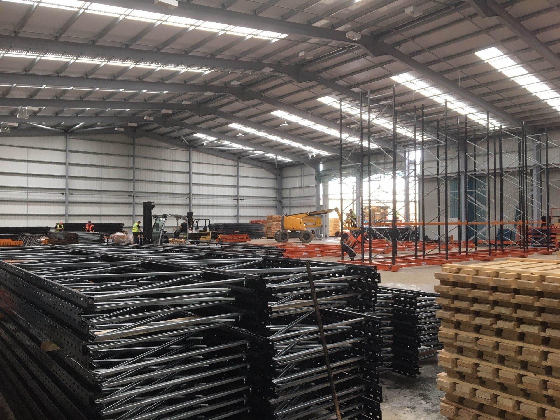 A large warehouse filled with lots of scaffolding and pallets
