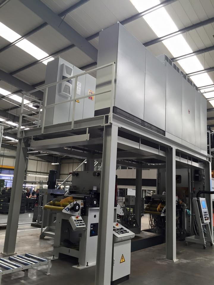 A large machine is sitting on top of a building in a factory.