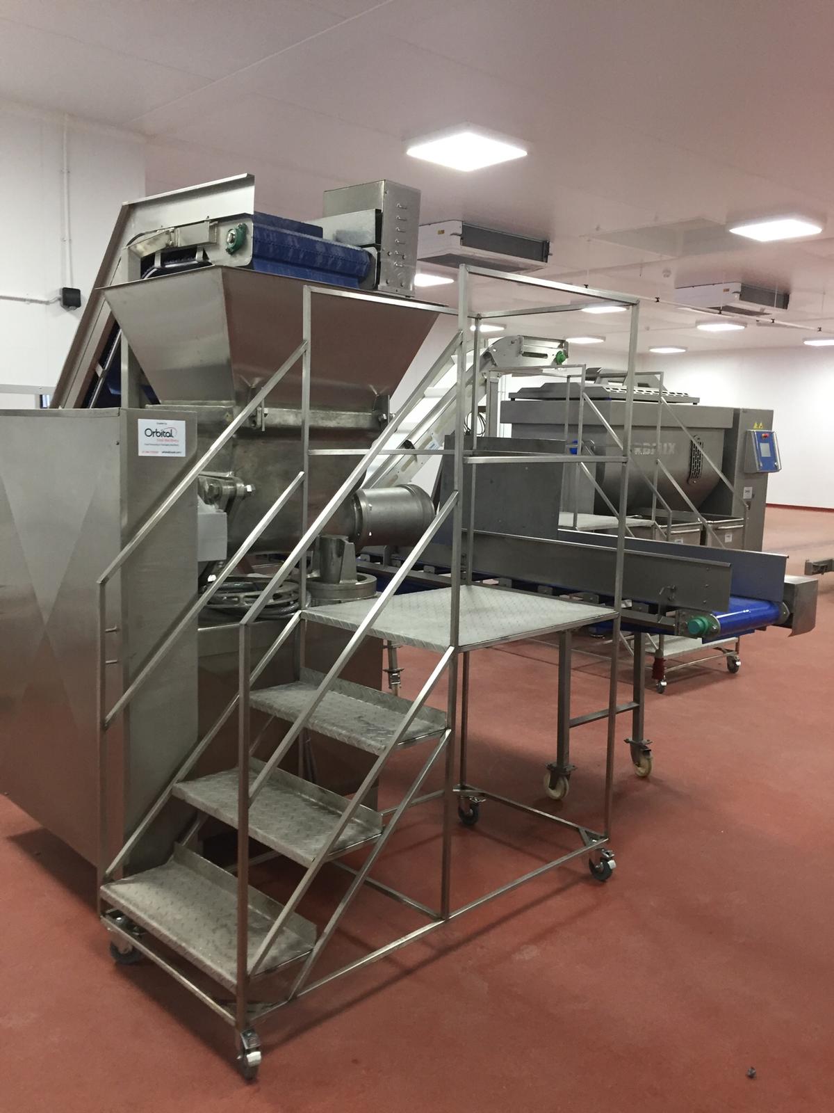 A staircase leading up to a machine in a factory.