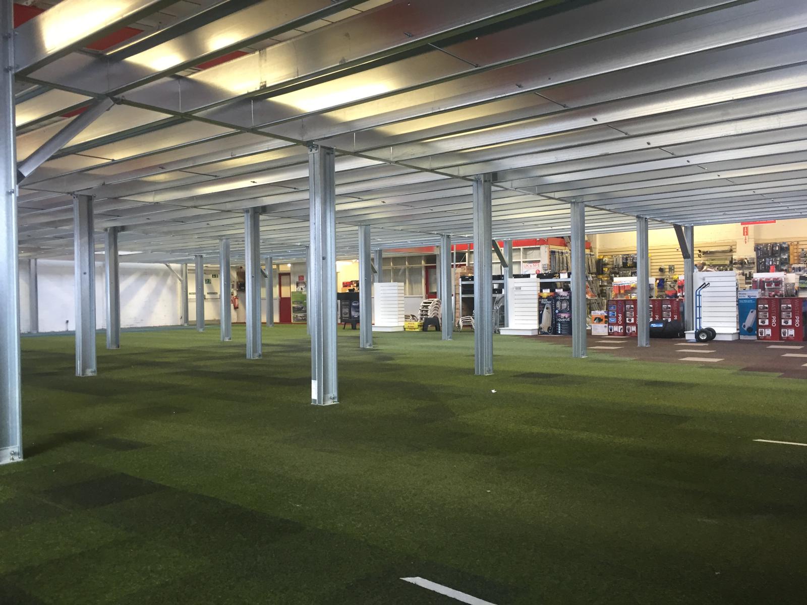 A large empty building with a lot of columns and a roof.