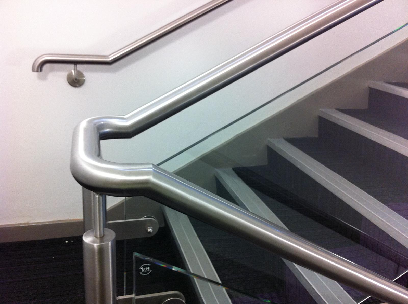 A staircase with a stainless steel railing and a glass railing