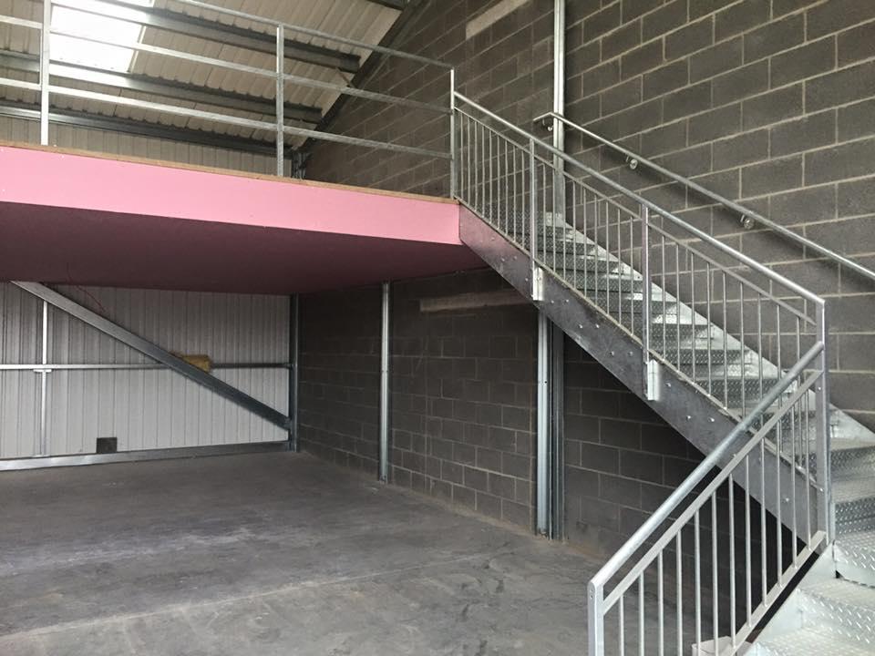 An empty building with stairs leading up to the second floor