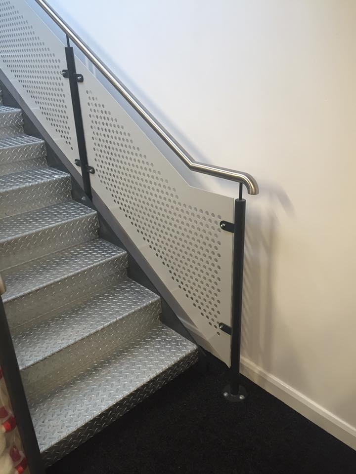 A staircase with a metal railing and a glass railing