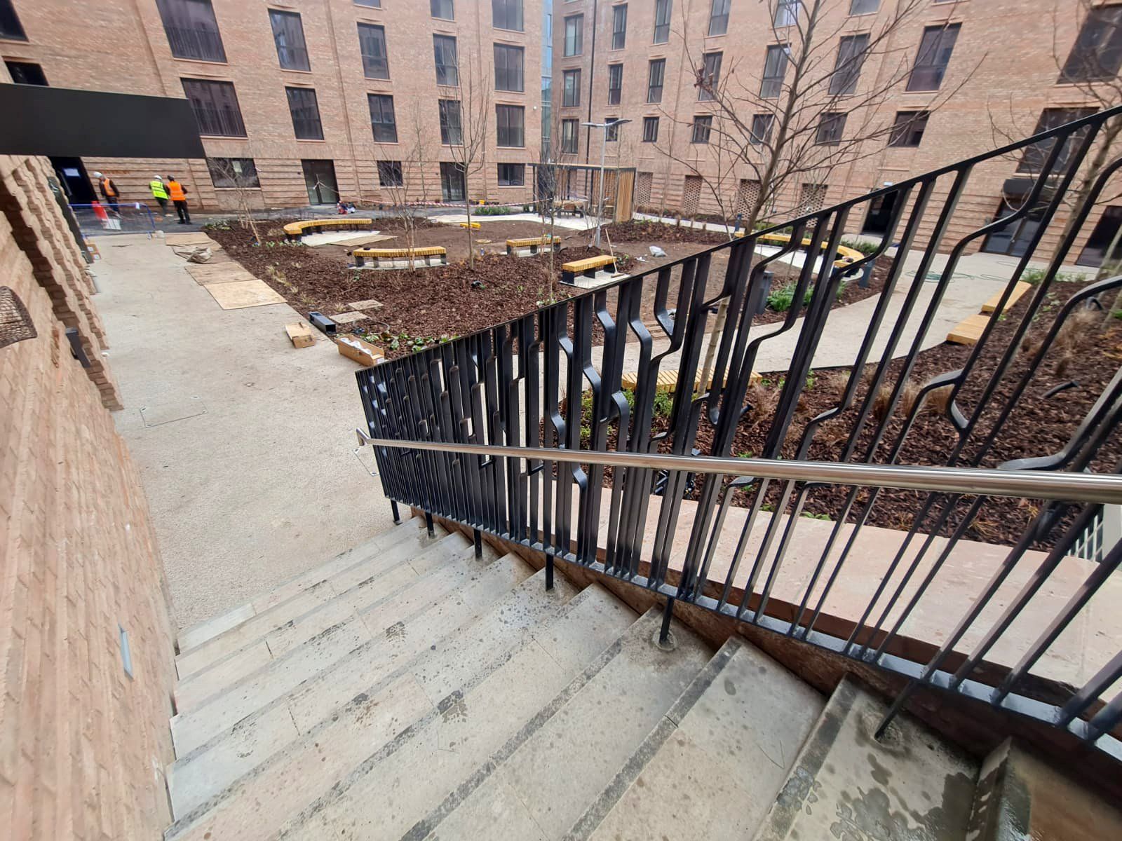 A set of stairs leading up to a building with a metal railing.