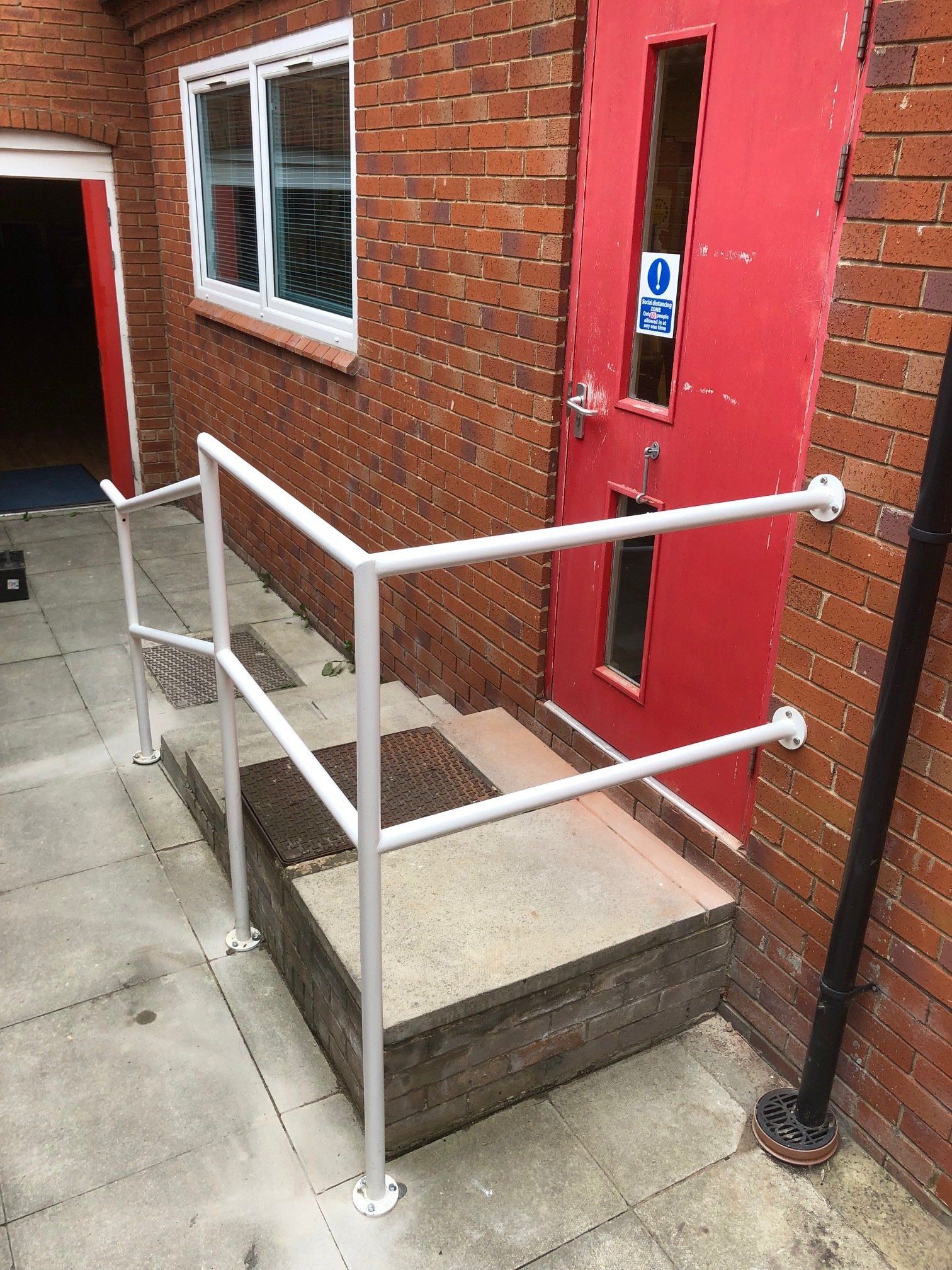 A red door with a white railing next to it.