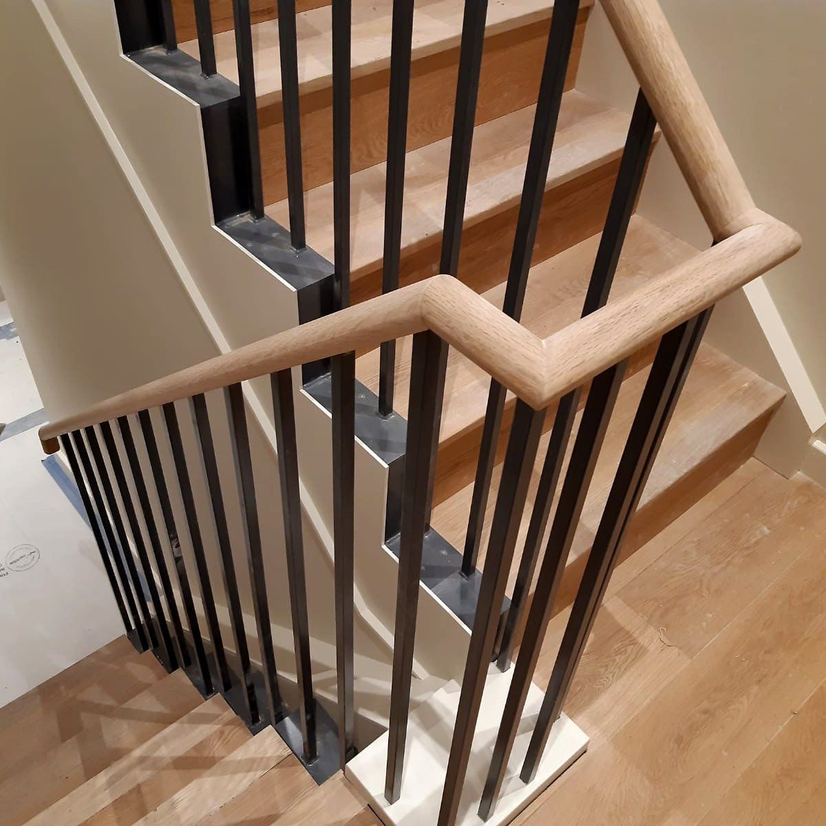 A staircase with a wooden handrail and metal railing