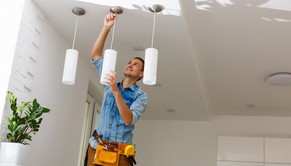 Male Electrician Fixing Light On Ceiling — Kernersville, NC — Hodges Triad Electric Co LLC