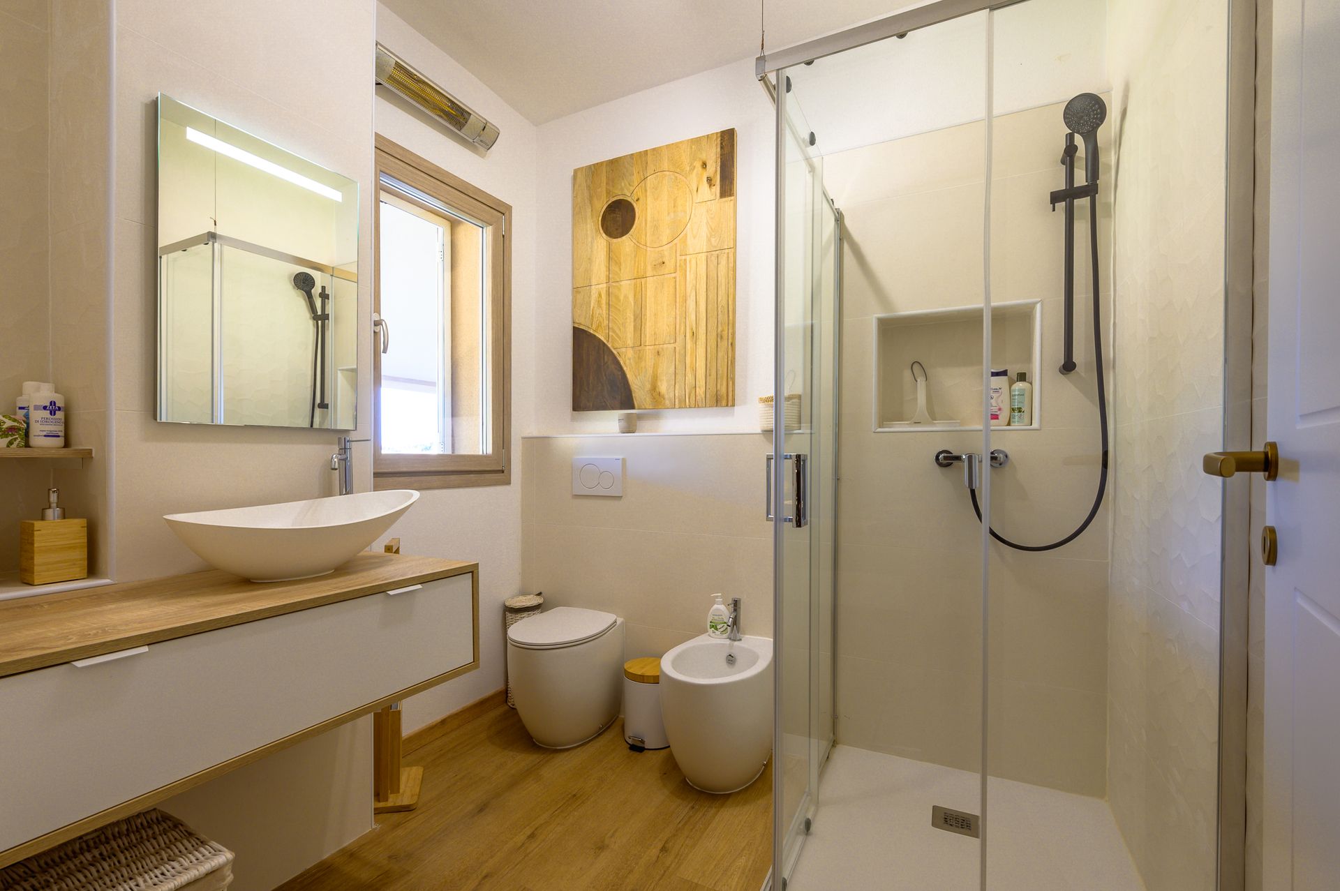 Bagno con dettagli in legno, pareti bianche e doccia in vetro.