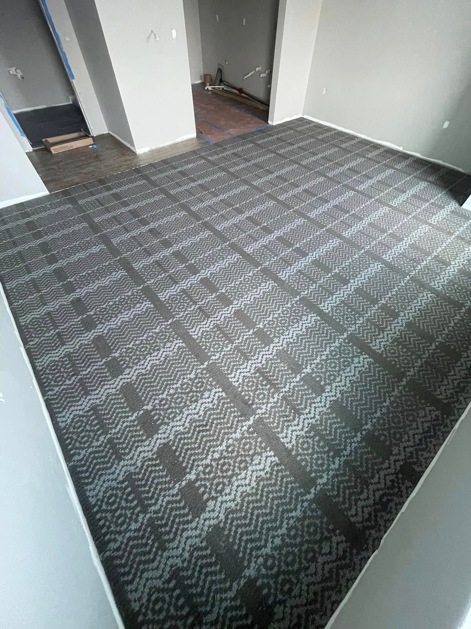 Room with patterned carpet and gray walls.