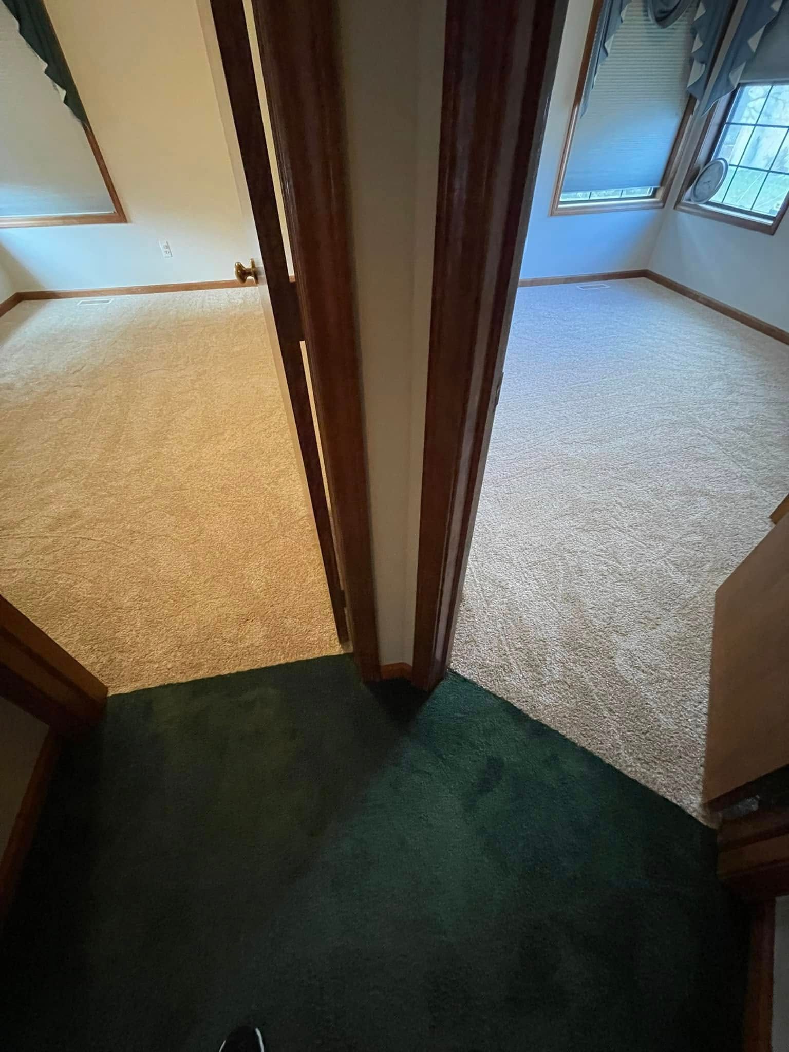 Hallway with three carpeted areas: tan, white, and green. Two doorways lead to rooms.